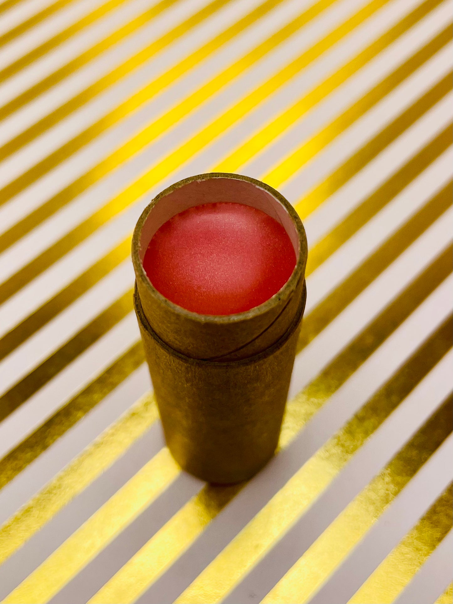 view inside the lip butter tube to show colour of product (light coral pink)
